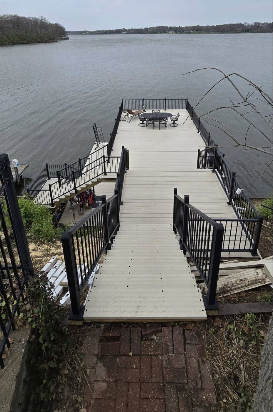 Rebuilt dock walkway with black metal railing and composite decking