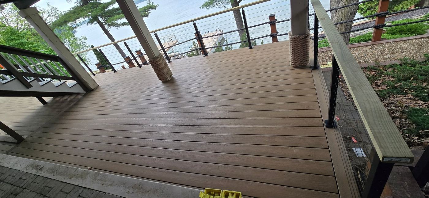 Composite deck with black cable railing overlooking the lake