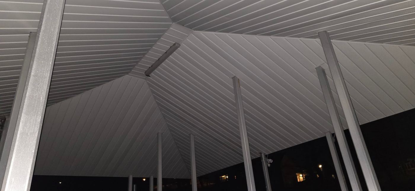 Hip roof structure over dock at night with lighting on